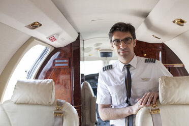Porträt eines männlichen Piloten in der Kabine eines Privatjets - ISF13981