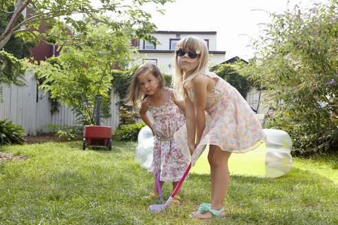 Mädchen spielen Kindergolf im Garten - ISF14005