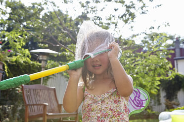 Mädchen mit Schmetterlingsnetz über dem Kopf im Garten - ISF14007