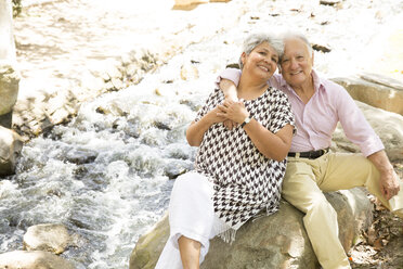 Portrait of senior couple sitting on rock, outdoors - ISF14026
