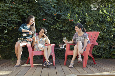 Drei Frauen trinken Weißwein auf einer Terrasse - ISF14030