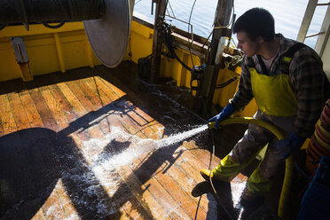Fischer wäscht Bodenbretter eines Trawlers - ISF14103