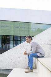 Pensive businessman sitting on steps outdoors - AFVF00640