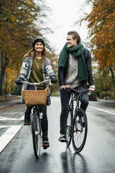 Young couple cycling on street - CUF33168