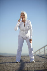 Ältere Frau trinkt Wasser beim Spaziergang - CUF33199