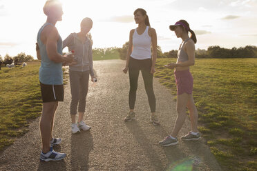 Personal Trainer mit einer Gruppe von Kunden, die sich auf einen Lauf vorbereiten - CUF33228