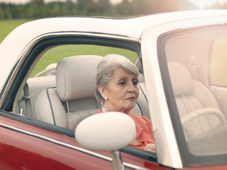 Ältere Frau fährt rotes Cabrio - CUF33231