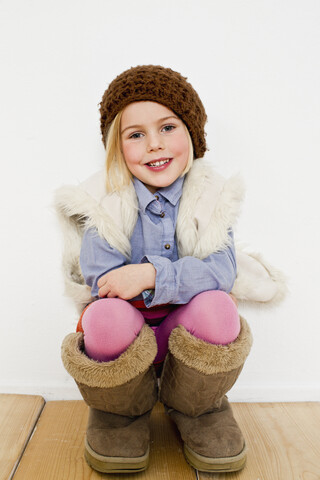 Studio portrait of young girl in oversize boots stock photo