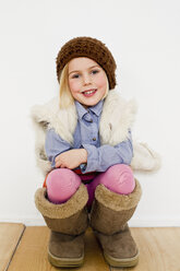 Studio-Porträt eines jungen Mädchens in übergroßen Stiefeln - CUF33283