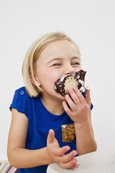 Studio portrait of young girl eating chocolate marshmallow - CUF33292