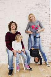 Studio portrait of couple waving fun with son and daughter - CUF33333