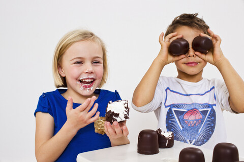 Studioaufnahme von Bruder und Schwester mit Schokoladen-Marshmallows, lizenzfreies Stockfoto