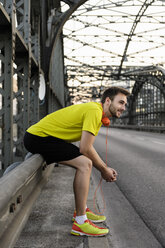 Young male runner resting on bridge - CUF33371