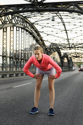 Junge Läuferin bereitet sich auf den Lauf auf der Brücke vor - CUF33379
