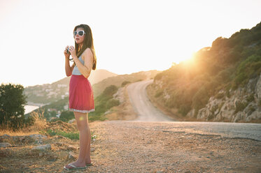 Mädchen hält Kamera bei Sonnenuntergang, Kas, Türkei - CUF33393