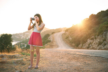 Girl taking photographs at sunset, Kas, Turkey - CUF33394