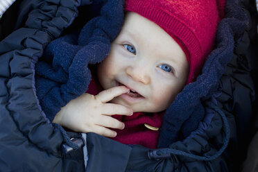 Portrait of baby girl in sleeping bag wearing hat - CUF33415
