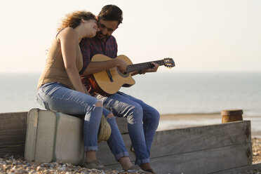 Junges Paar am Strand, Mann spielt Gitarre - CUF33426