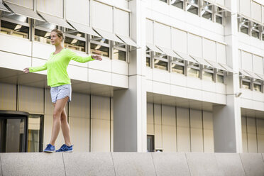 Young woman walking on wall - CUF33441