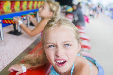 Porträt eines Mädchens, das an einem Jahrmarktsstand Grimassen schneidet - ISF14122