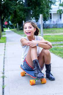 Porträt eines Mädchens auf einem Skateboard sitzend auf einem Weg - ISF14138