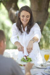 Wife serving salad to husband - CUF33511