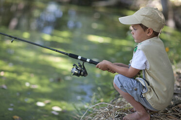 Boy fishing by stream - CUF33517