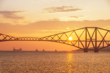 Vereinigtes Königreich, Schottland, Firth of Forth, Forth Rail Bridge mit Schleppern darunter und Hound Point Oil Loading Marine Terminal bei Sonnenuntergang - SMAF01046