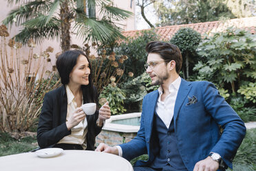 Elegantes Paar im Gespräch in einem Gartencafé - ALBF00541