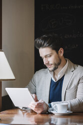 Businessman using tablet in a cafe - ALBF00551