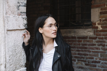 Young woman at old brick building looking around - ALBF00564