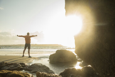 Mature man exercising on beach, looking out to sea - CUF33702