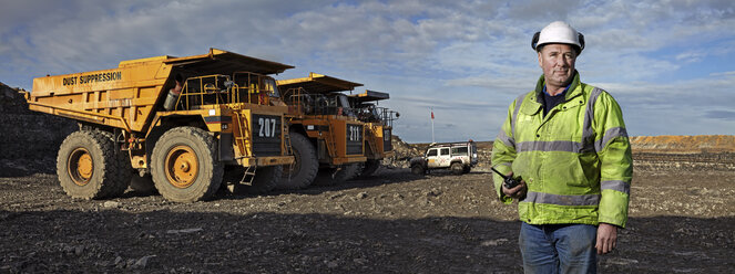 Porträt eines Vorarbeiters mit Walkie-Talkie bei der Arbeit im Steinbruch - CUF33706