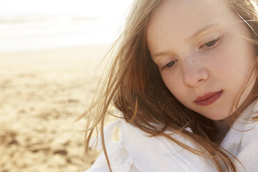 Close up portrait of girl wrapped in blanket on beach - CUF33717