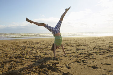 Mädchen macht Handstand am Strand, Camber Sands, Kent, UK - CUF33722