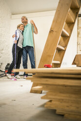 Happy senior couple holding brooms - CUF33762