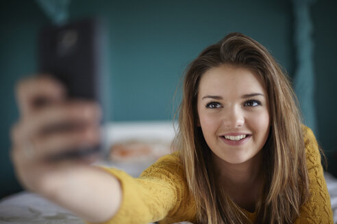 Teenager-Mädchen im Schlafzimmer nimmt ein Selfie - CUF33776