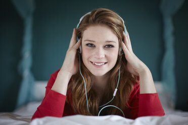 Portrait of teenage girl in bedroom listening to music - CUF33778