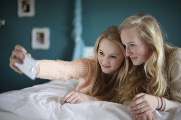 Two teenage girls taking selfie in bedroom - CUF33779