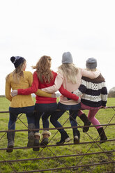 Rückansicht von vier Teenager-Mädchen, die auf einem Tor sitzen - CUF33792