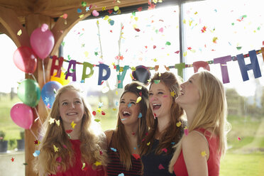 Vier Mädchen im Teenageralter erfreuen sich an Konfetti auf einer Geburtstagsparty - CUF33811