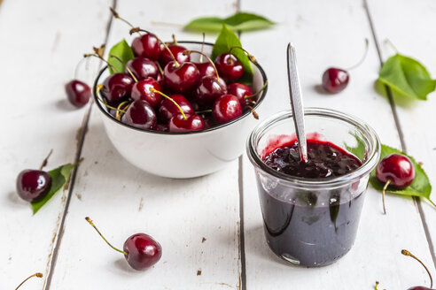 Jar of cherry jam and cherries on white wood - SARF03802