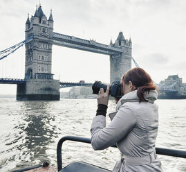 Female photographer taking photograph of Tower Bridge London, UK - CUF33937