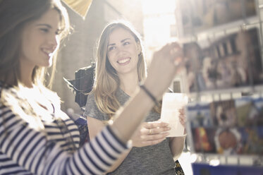 Two young female friends looking at postcards, Valencia, Spain - CUF34004