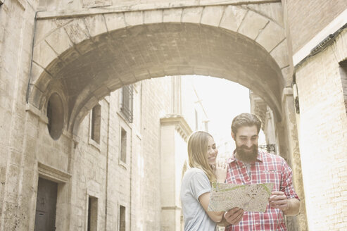 Junges Paar mit Blick auf die Landkarte vor der Kathedrale von Valencia, Valencia, Spanien - CUF34011