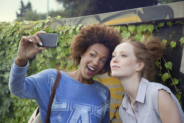 Zwei junge Frauen fotografieren sich selbst mit dem Smartphone - CUF34029