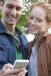 Junges Paar schaut auf Smartphone - CUF34054