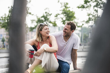 Happy couple sitting on a bench - UUF14289