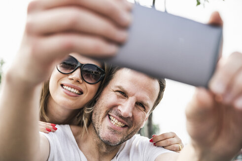 Glückliches Paar macht ein Selfie im Freien - UUF14295