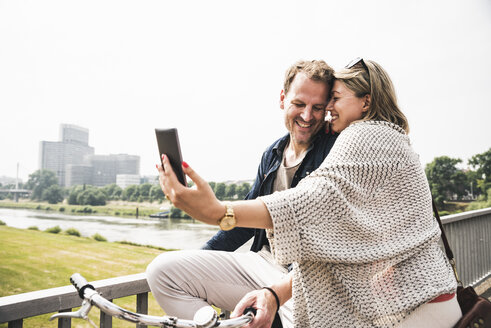 Glückliches Paar macht ein Selfie auf einer Brücke - UUF14307